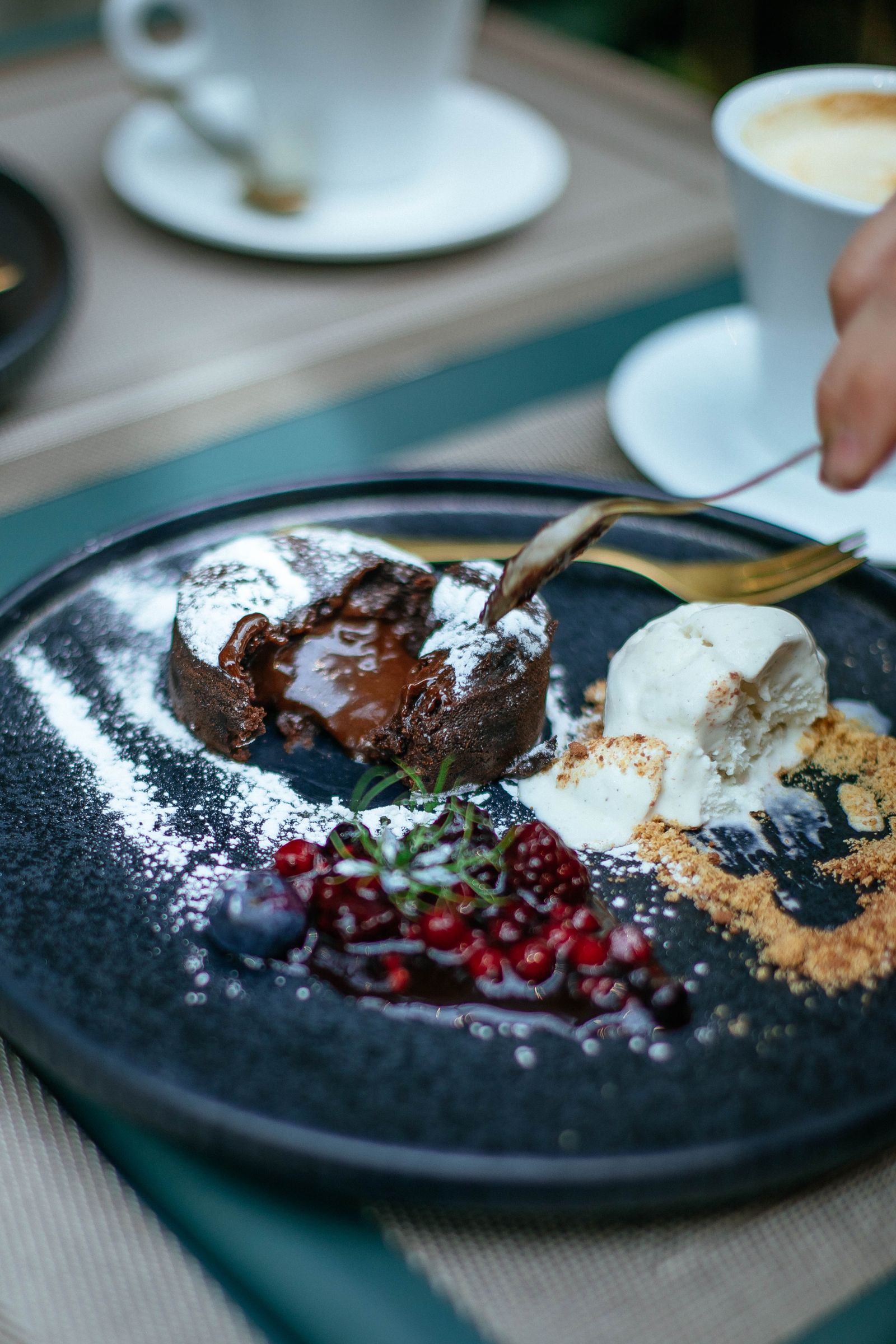 Tortino al cioccolato dal cuore fondente con frutti di bosco e gelato.